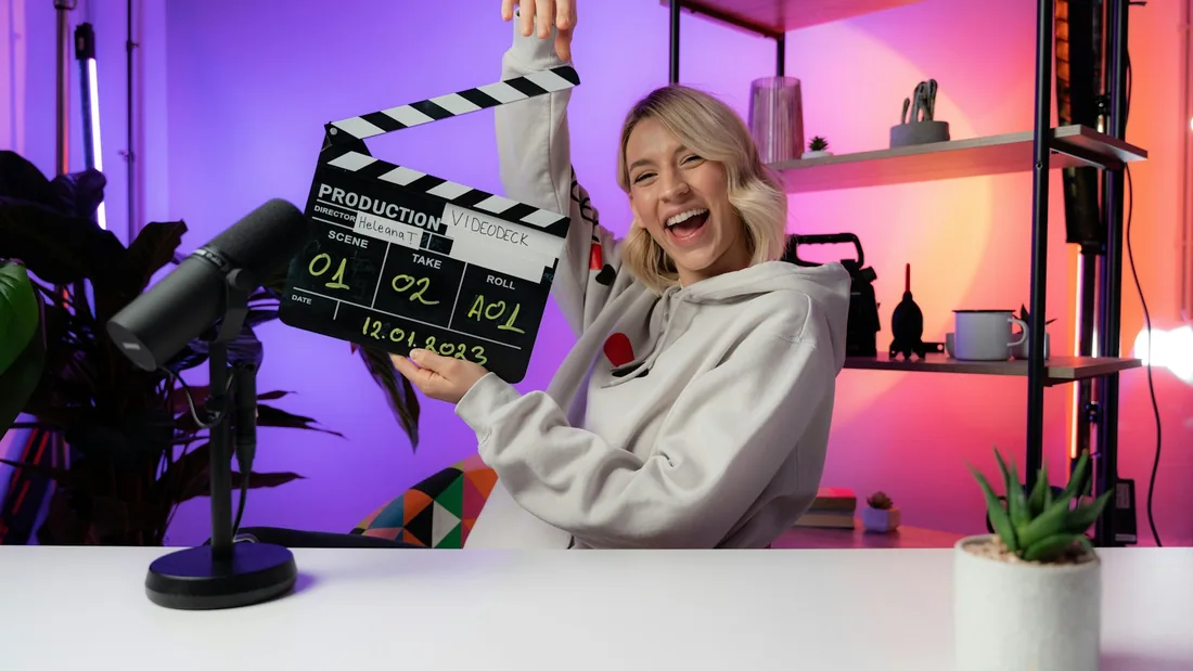 Klapka a filmová kamera na stativu v zatemněném ateliéru připraveném ke snímání